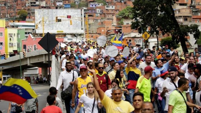 Manifestantes caminan por una zona popular de Caracas