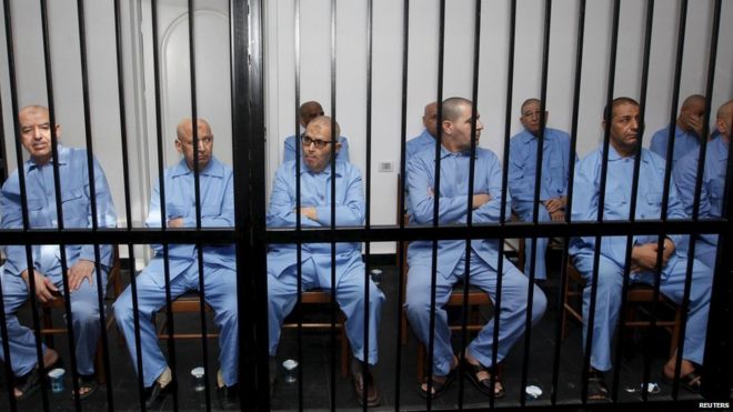 Former Gaddafi regime's officials sit behind bars during a verdict hearing at a courtroom in Tripoli, Libya July 28, 2015