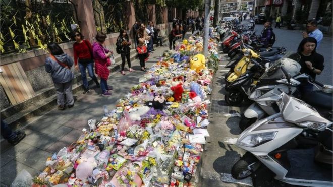 People offer flowers and prayers for a four-year-old child victim of a random killing, at a makeshift memorial at a street next to the crime scene, in Taipei, Taiwan, 29 March 2016.