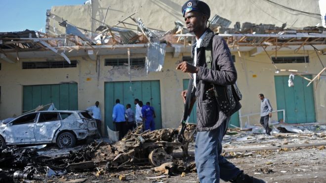 A member of the Somali security forces stands guard at the site of a bomb blast near Makka al-Mukarama Road in Mogadishu on December 19, 2015.