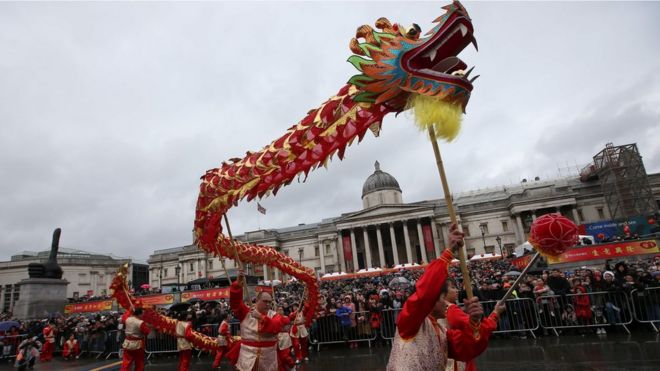 Members of the Chinese community perform a "dragon dance" in a front of a crowd backed by the National Gallery