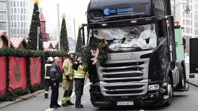 This file photo taken on December 20, 2016 shows firemen inspecting the truck that crashed the evening before into a Christmas market in Berlin.