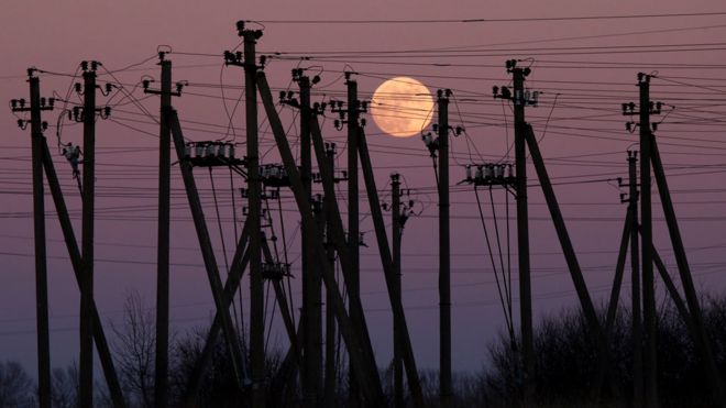 Luna llena entre torres de electricidad en Virbalis, Lituania