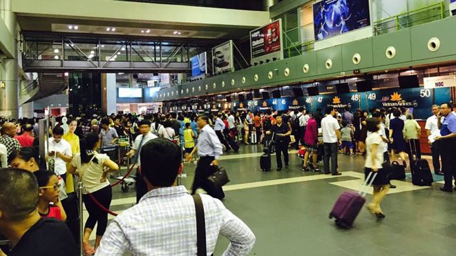 Passengers crowd at check-in counters at Noi Bai Airport in Hanoi, Vietnam Friday, July 29, 2016