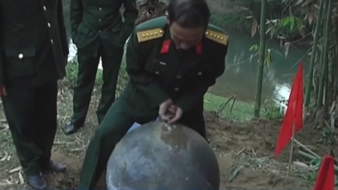 An official in uniform trying to lift one of the orbs