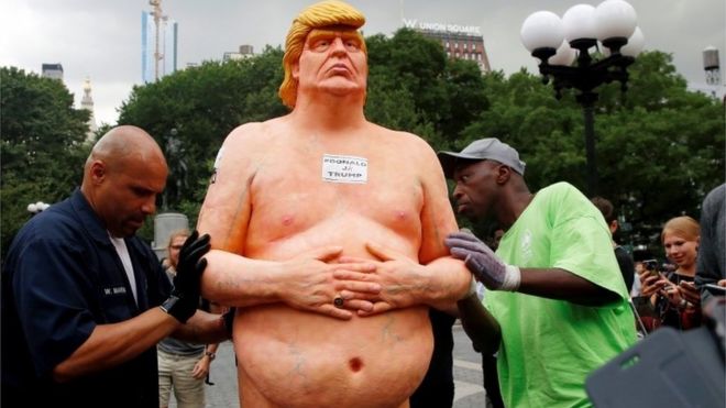New York City Parks workers check a statue of Trump in Union Square