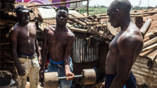 Titus Alukwe, Ben Oloo and Johnstone Mainah do some daily workout routine with homemade weights in Kibera slum in Kenya