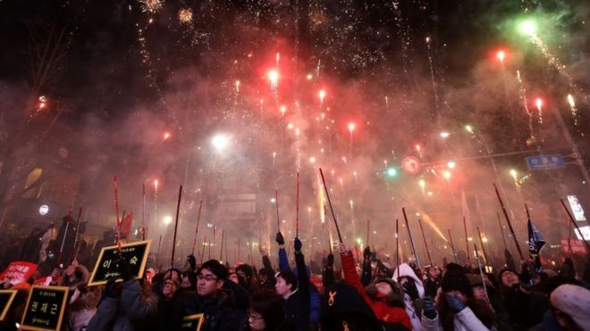 Fireworks illuminate the sky during a rally against South Korean President Park Geun-Hye on 10 December