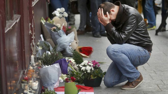 A man pays his respect outside the Le Carillon restaurant the morning after a series of deadly attacks in Paris , November 14, 2015.