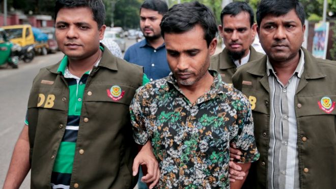 Members of Bangladesh Police Detective Branch (DB) escort a man, centre, whom they have identified as Shariful Islam Shihab, a former member of the banned Islamic group Harkatul Jihad as they walk him in front of the media in Dhaka, Bangladesh, Sunday, May 15,