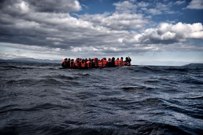 Migrants crowded on a flimsy boat at sea