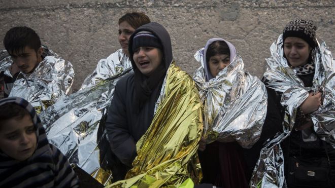 Migrants wrapped in metal blankets on their arrival in Europe