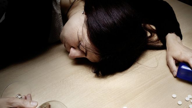 Drogadicta dormida sobre una mesa