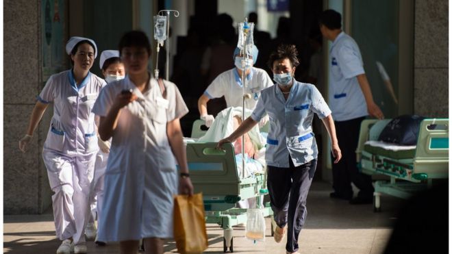 Hospital staff rushing to treat a victim of the Kunshan car parts factory disaster