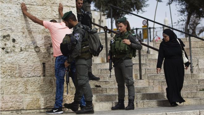 Israeli border policemen perform a security check on a Palestinian youth at Damascus Gate just outside Jerusalem's Old City before Friday prayers on 23 October 2015