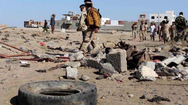 Soldiers gather the site of a suicide bomb at a base in the southern city of Aden, Yemen, 18 December.