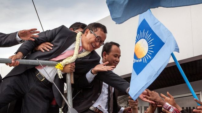 Cambodia National Rescue Party President Sam Rainsy greets supporters at Phnom Penh International Airport after arriving in Cambodia on July 19, 2014 in Phnom Penh, Cambodia