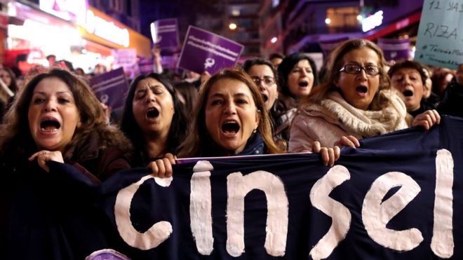 Turkish female protesters shout slogans against the government as they hold placards reading "Rape cannot be legalized"