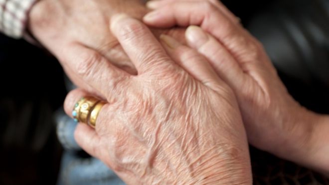 Carer holding an elderly patient's hand