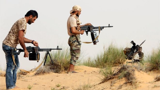 Fighters from a militia in Libya load their weapons