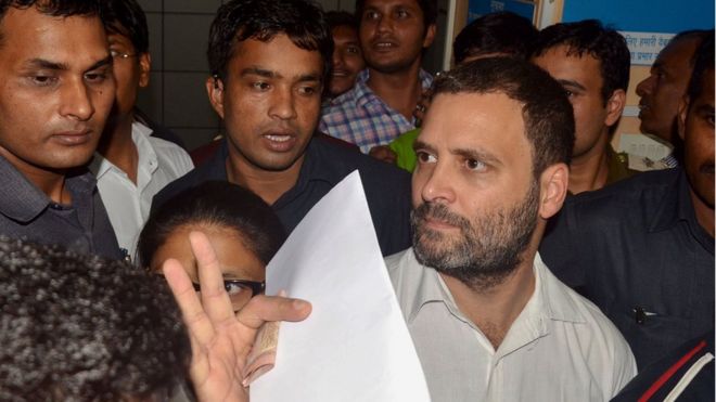 Indian National Congress vice-president Rahul Gandhi carries a bank form as he exchanges rupee notes of the old denomination at a bank in New Delhi on November 11, 2016