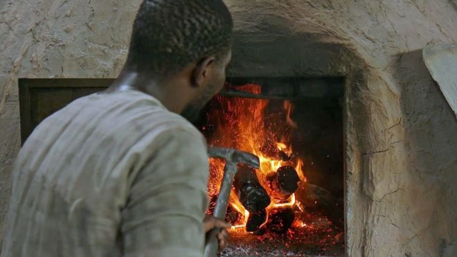 A man tends the bakery fire
