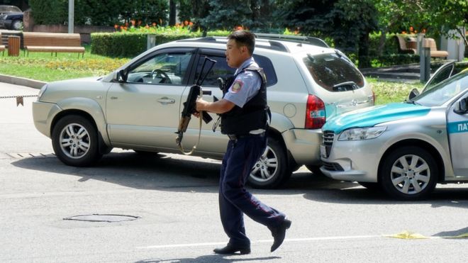 A policeman runs across the street in Almaty