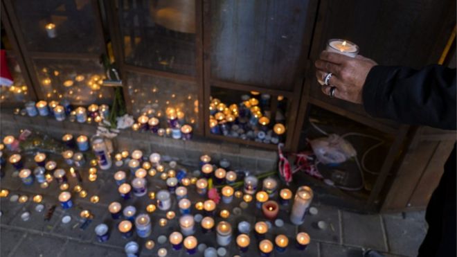 An Israeli man stops to light a candle at a memorial in the entrance of the cafe in Tel Aviv, Israel, 02 January 2016