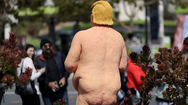 People look at a Trump statue in San Francisco