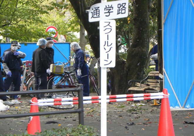 policemen investigate an explosion site at a park in Utsunomiya on October 23, 2016.