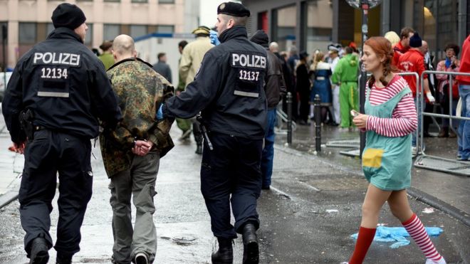 Policemen arrest a man during Weiberfastnacht celebrations as part of the carnival season on February 4, 2016 in Cologne, Germany.