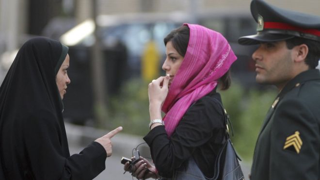 A member of Iran's morality patrols (l) in Tehran admonishes a young woman (c) for her dress in April 2007.