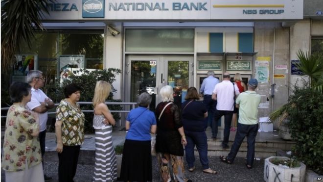 People stand in a queue to use an ATM outside a closed bank, next to a sign on the plant, bottom right, reading ""NO"" in Athens, Tuesday, June 30, 2015.