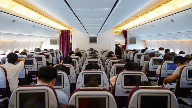 Una cabina de avión con pasajeros a bordo