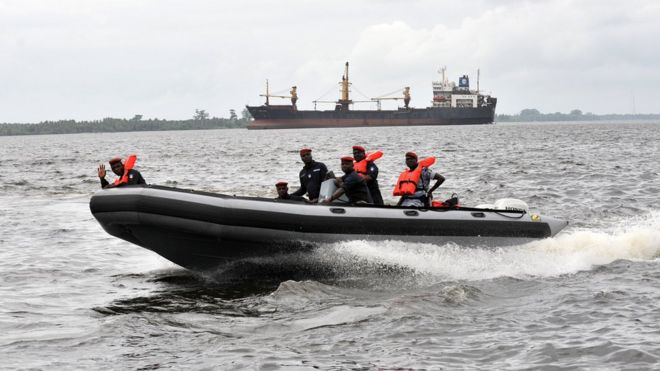 Coast guard officers sit in a speed boat during a patrol, at the port of Abidjan, in 2012