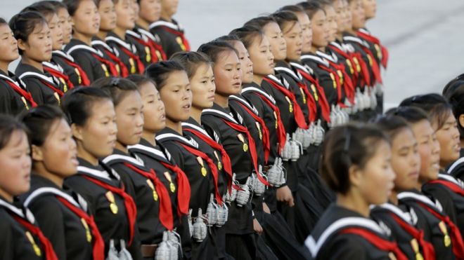 Schoolgirls wearing fake grenades during the military parade for the 70th anniversary of the founding Workers' Party, Pyongyang, North Korea - Saturday 10 October 2015