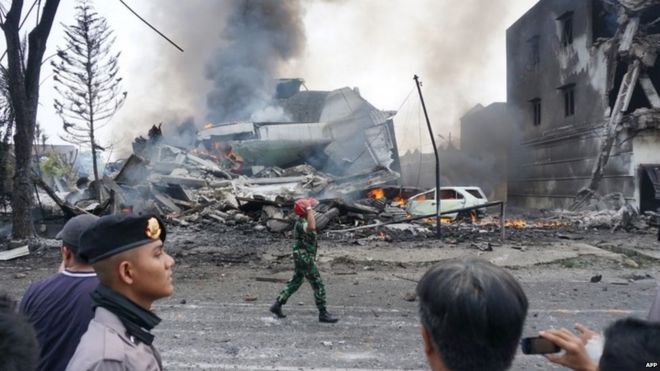 Indonesian police and military officials secure the crash site of military Hercules plane in Medan, North Sumatra (30 June 2015)