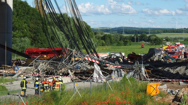 Firefighters stand near a collapsed scaffolding at a highway bridge near Werneck northern Bavaria, Germany Wednesday June 15, 2016. German news agency dpa is reporting that the scaffolding has collapsed on a highway bridge that was under construction in southern Germany.