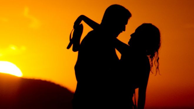 Couple on a beach at sunset, file pic