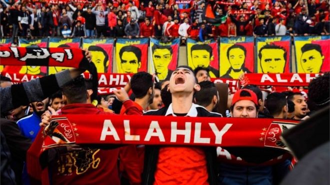 A supporter holds a scarf of 
