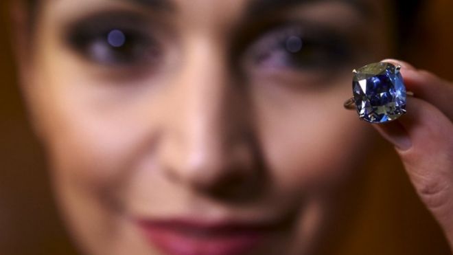 A model poses with the 12.03 carat cushion-shaped Blue Moon diamond (11 November 2015)