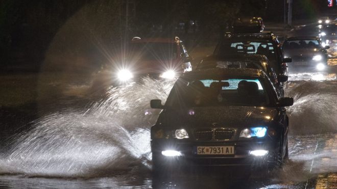 Cars struggling through flooded roads in the dark, 6 August 2015