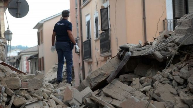 A police officer searches for victims in damaged buildings after the quake hit Amatrice (24 August 2016)
