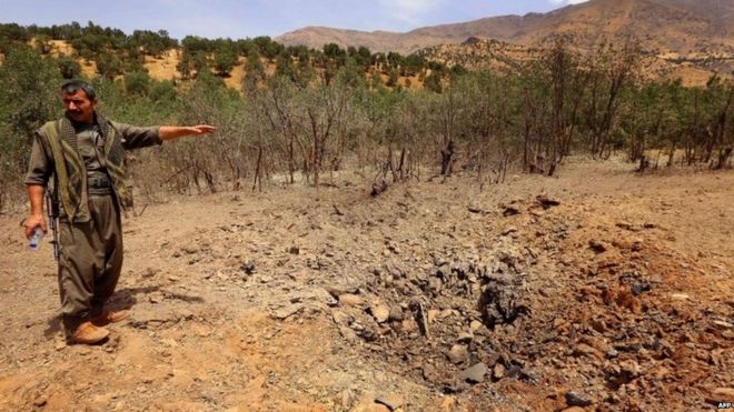 A PKK fighter inspects a crater reportedly caused by a Turkish air strike in the Qandil mountain 29.07.2015