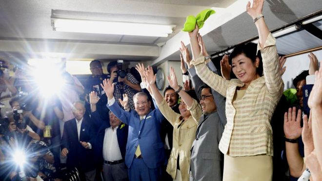 Yuriko Koike (right) and her supporters celebrate after exit polls predicted her election victory in Tokyo, Japan. July 31, 2016