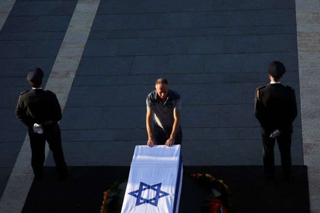 تابوت شیمون پرز در بیرون ساختمان پارلمان اسرائیل در بیت‌المقدس قرار گرفته و در این عکس یک مرد در حالی که دو سرباز گارد تشریفات کنار تابوت ایستاده اند به آن احترام می‌گذارد