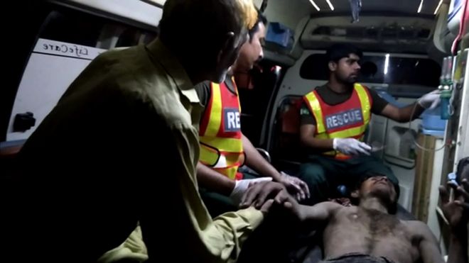 Sadaqat Ali being treated by medical workers