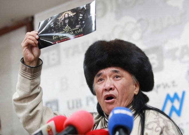 Sevjidiin Sukhbaatar, the father of injured Mongolian rapper Amarmandakh Sukhbaatar, holds up a poster featuring a swastika symbol at a press conference about his son in Ulan Bator, Mongolia, on December 2, 2016.