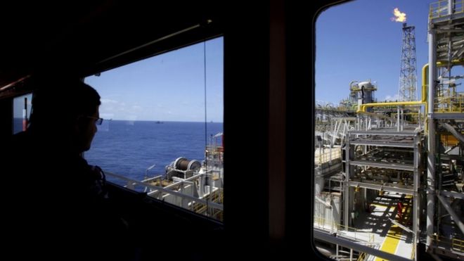 Oct. 28, 2010 file photo, an oil worker looks at a Petrobras offshore ship platform over Tupi field in Santos Bay off the coast of Rio de Janeiro, Brazil