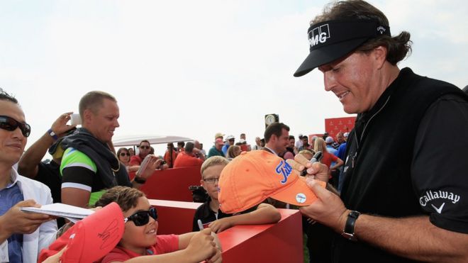 Golfer Phil Mickelson signs an autograph